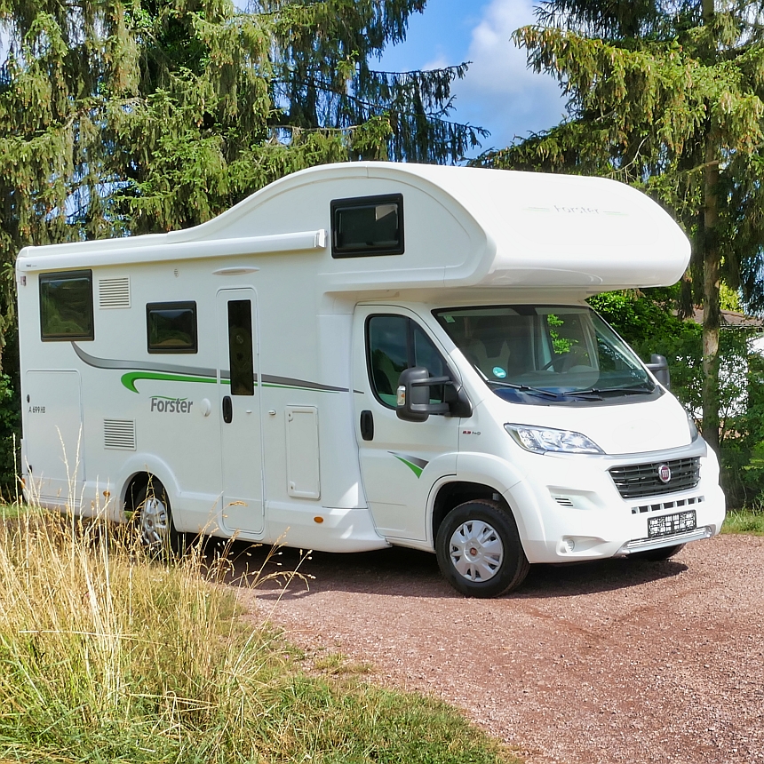 weißes Wohnmobil im Wald